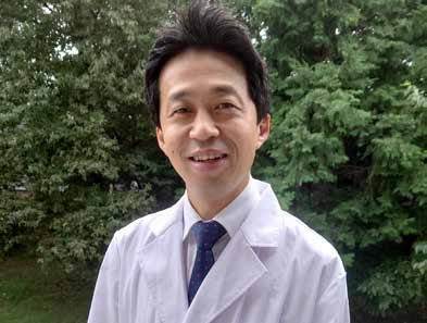 Takeo Igarashi im weißen Laborkittel vor Bäumen