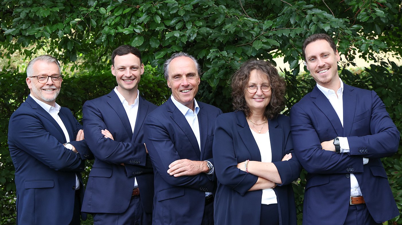 Das Team Executives von Almit, fünf Personen vor einer Hecke